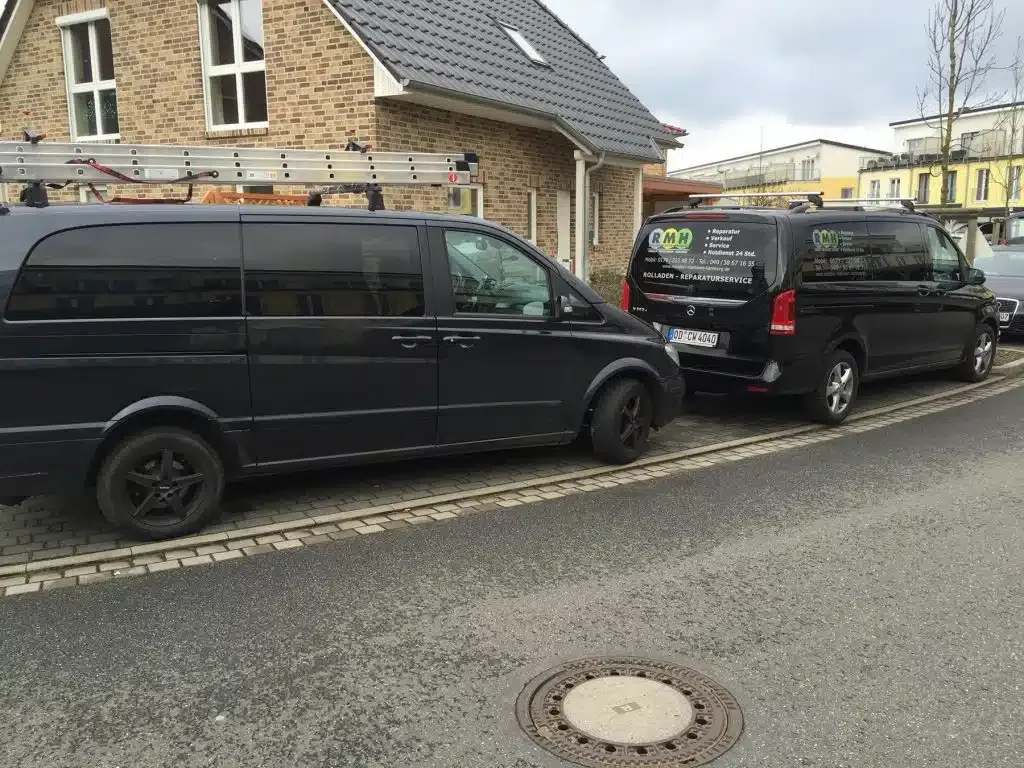 Zwei Lieferwagen parken Rücken an Rücken auf einer Stadtstraße und teilen sich einen Parkplatz.
